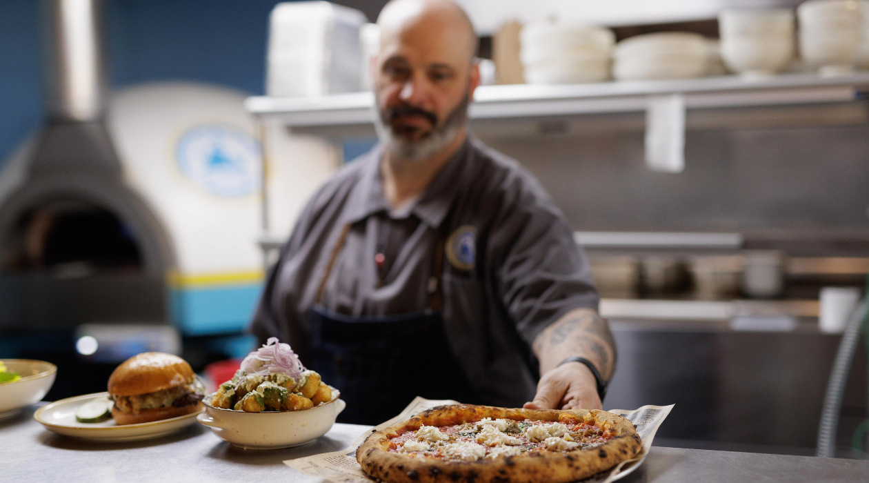 Chef Adam Slamon plating pizza at Sloop Brewing Co